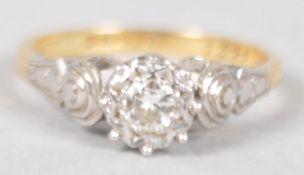 A yellow and white metal ring set with a single round brilliant cut diamond.