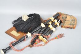 A set of bagpipes and a mounted sporran with presentation plaque