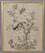 An early 19th century silk embroidery of a goldfinch confronting a caterpillar in a tree,