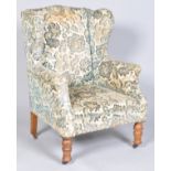A Victorian wing back armchair on turned tapering legs and casters, 104cm high overall,