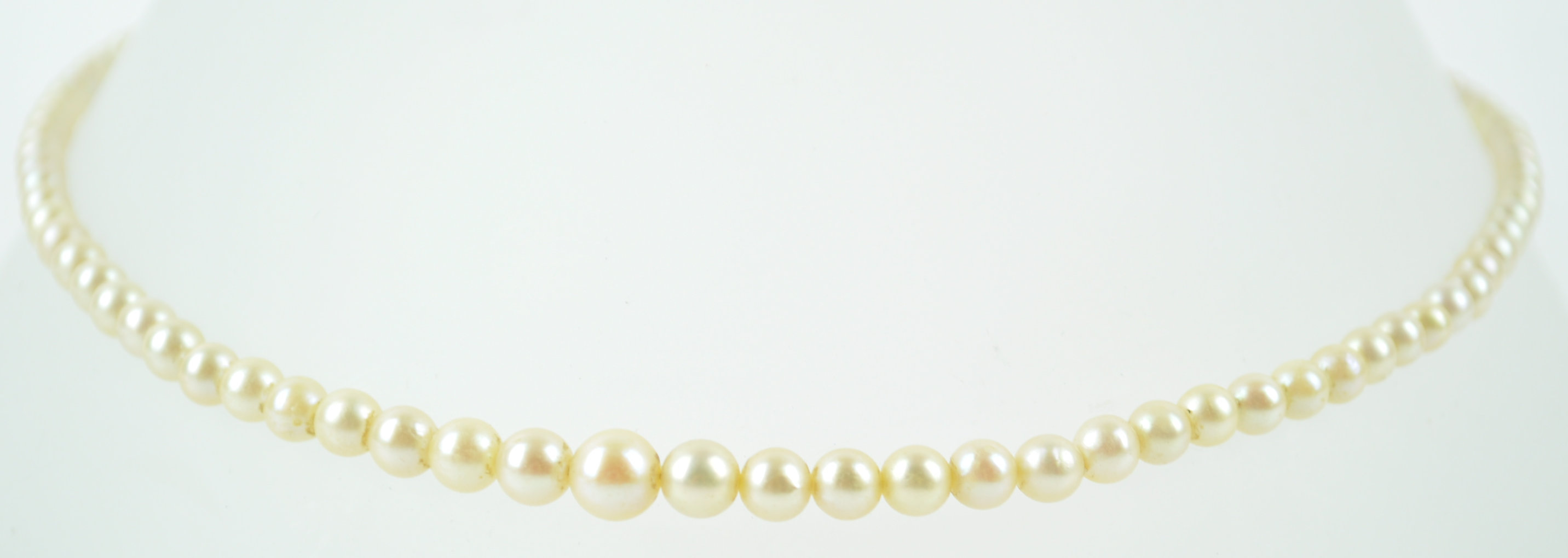 An 8mm white cultured pearl together with a single strand of graduated simulated pearls