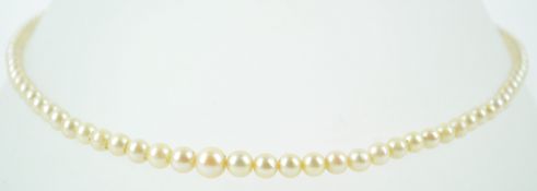 An 8mm white cultured pearl together with a single strand of graduated simulated pearls