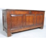 An oak coffer, of panelled construction, with hinged plank top,