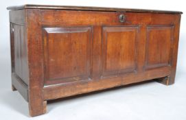 An oak coffer, of panelled construction, with hinged plank top,