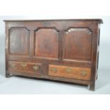 A George II oak mule chest, the hinged plank top above panelled front and sides,