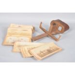 A Stereoscope, with wooden stand and magnifying glass, together with mounted photos,