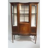 An Edwardian mahogany display cabinet with concave central glazed panel