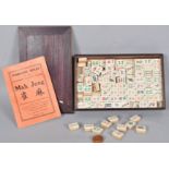 A vintage mahjong set having bone and bamboo tiles with dove tail joints,