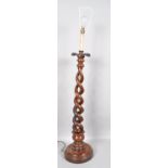A bespoke mahogany turned and carved candle stand, converted to electric,