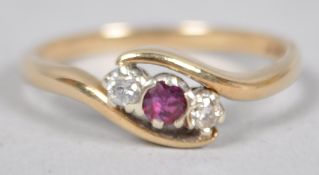 A yellow metal dress ring principally set with a round faceted cut ruby