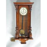 A mahogany cased Vienna style wall clock with two applied turned columns and a crop base