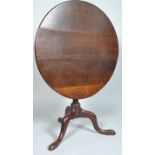 A 19th century George II oak tilt top table on baluster stem with three cabriole legs