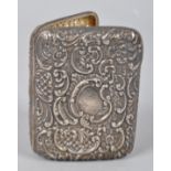 A silver cigarette case, extensively repousse decorated with c scroll floral decoration, 9cm x 7cm