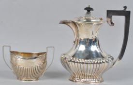 A silver coffee jug, of shaped baluster form, with a ribbed base and cover,