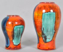 A Poole pottery gemstone vase of baluster form, with typical bright decoration on an orange ground,