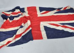 A large linen Union Jack ensign, World War II era with wooden toggle and rope,