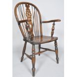 An elm Windsor chair with spindle and wheel splat on turned baluster legs, 103cm high,