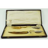 A Solingen gilded serving knife and fork, with embossed white metal handle,