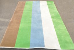 A contemporary rectangular rug with green, cream, blue, ivory and brown stripes - 183 cm. x 274 cm.