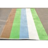 A contemporary rectangular rug with green, cream, blue, ivory and brown stripes - 183 cm. x 274 cm.