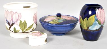 A Moorcroft Magnolia pattern blue ground powder bowl and cover, a similar ovoid vase,