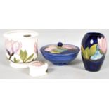 A Moorcroft Magnolia pattern blue ground powder bowl and cover, a similar ovoid vase,