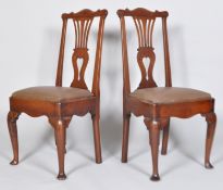 A pair of George II oak hall chairs, with pierced vase shaped splat and scroll top rail,
