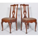 A pair of George II oak hall chairs, with pierced vase shaped splat and scroll top rail,