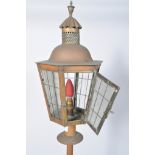 A brass standard lamp, with glass lantern shaped top,
