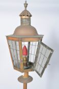 A brass standard lamp, with glass lantern shaped top,