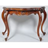 A 20th century mahogany console table of shaped form with carved frieze on carved cabriole legs,