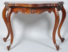 A 20th century mahogany console table of shaped form with carved frieze on carved cabriole legs,