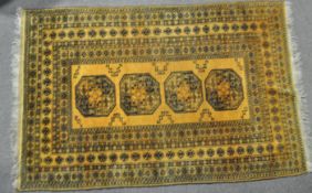 A yellow rug with central panel woven with octagonal medallions within geometric panels of foliate,