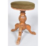 A Victorian revolving piano stool, the carved oak baluster support on three carved cabriole legs,