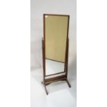 An oak framed rectangular cheval mirror on a plain stand with brass urn finials, 160cm high,