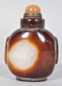 A Chinese carved agate snuff bottle with a brass mounted cornelian stopper,