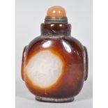 A Chinese carved agate snuff bottle with a brass mounted cornelian stopper,