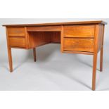 A 1950's retro teak office desk, the plain top above two banks of drawers on tapering legs,