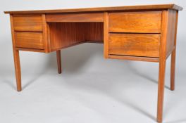 A 1950's retro teak office desk, the plain top above two banks of drawers on tapering legs,