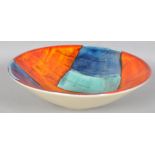 A Poole pottery gemstone centre bowl, decorated in typical palette on an orange ground,