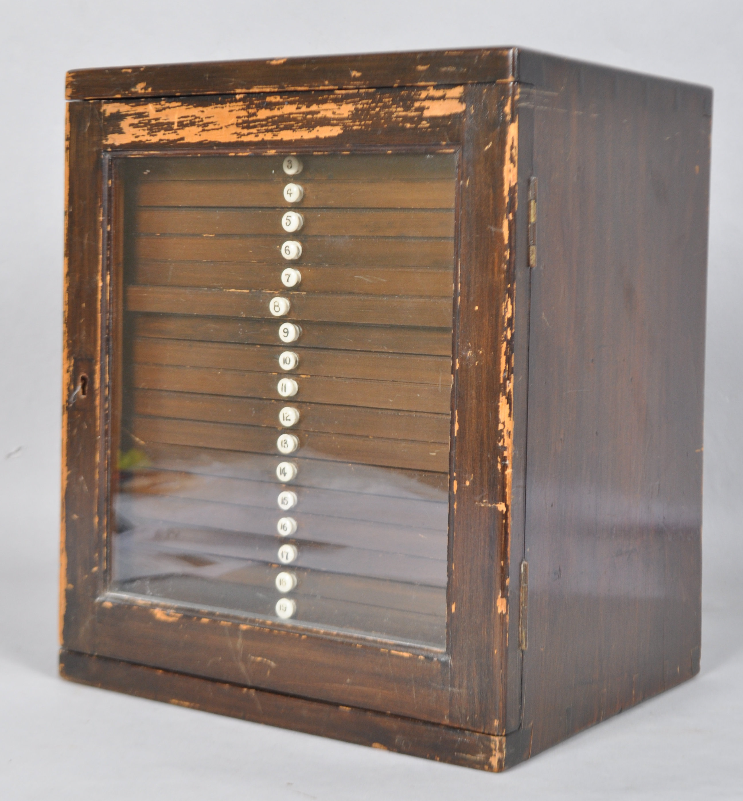 An Edwardian mahogany collectors cabinet, the glazed door enclosing twenty numbered drawers,