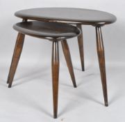 A nest of two Ercol dark-stained pebble-shaped tables, each on splayed legs - 49 cm. wide max.