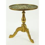 A 19th century brass trivet in the form of a tripod table with baluster stem and pierced top,