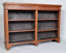 A carved oak bookcase of rectangular section with two divisions and four adjustable shelves,