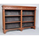 A carved oak bookcase of rectangular section with two divisions and four adjustable shelves,