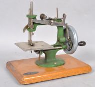 A mid 20th century "Grain" Mark I miniature sewing machine, on wooden plinth base,