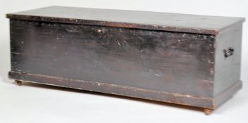 A pine blanket box of rectangular form, with hinged top and handles painted black overall,