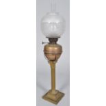 A large brass and copper fluted Corinthian column oil lamp with acid etched globe shade,