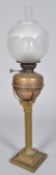 A large brass and copper fluted Corinthian column oil lamp with acid etched globe shade,