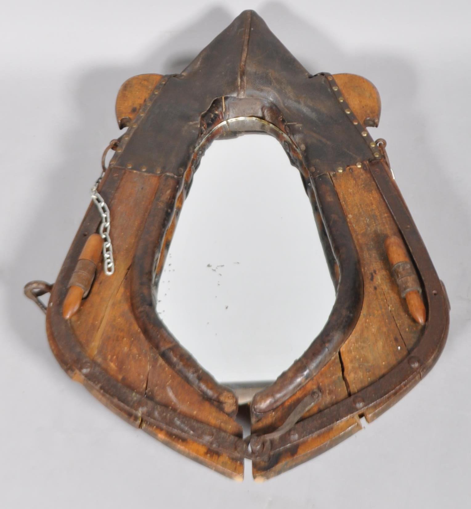 A 20th century vintage oak horse ploughing collar having steel furniture and studded leather,